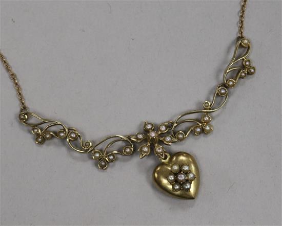 An early 20th century 9ct gold and seed pearl set heart shaped drop pendant necklace, approx. 52cm